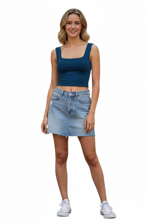 Hippy Haven model wearing a blue scoop neck crop tank top with a denim skirt and white sneakers